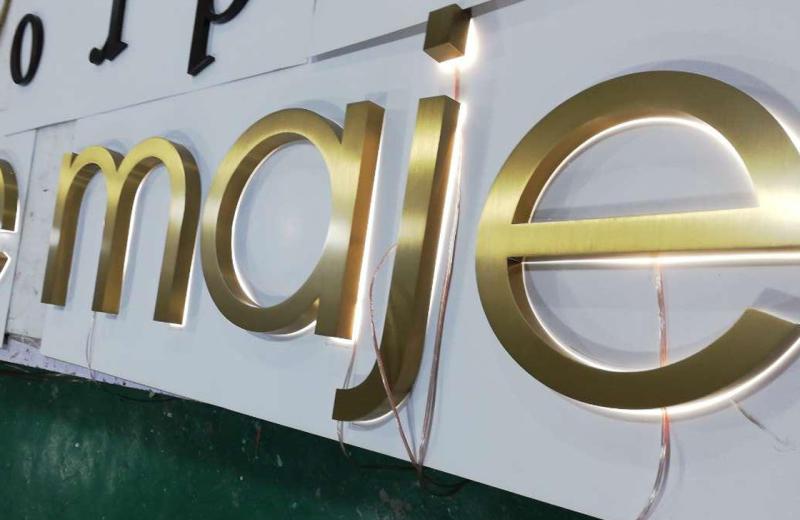 maje-brass-signage-with-illumination-glow