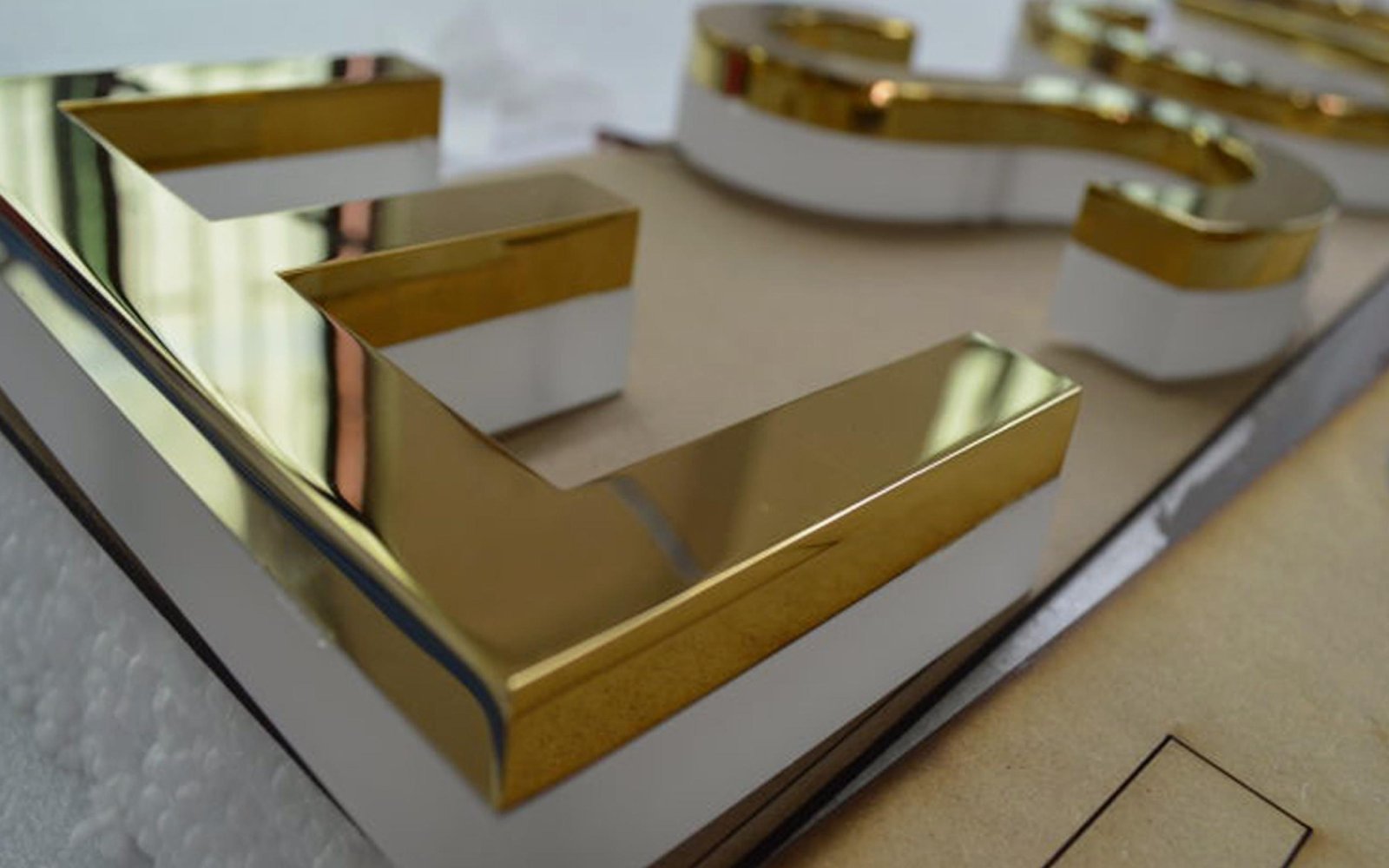 close-up-of-brass-mirror-letter-with-acrylic-underneath